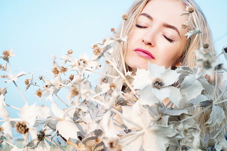 woman behind white petaled flower thumbnail