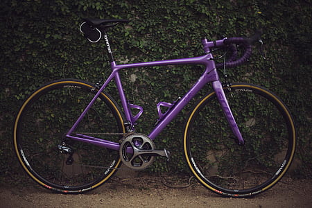 purple road bike leaning on wall thumbnail