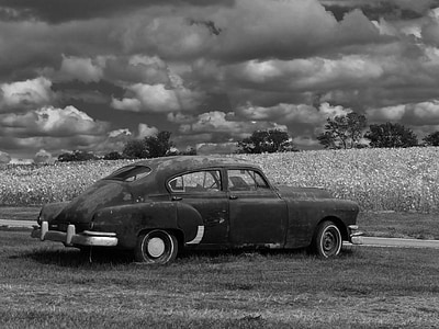 greyscale photo of vintage car on farm field thumbnail