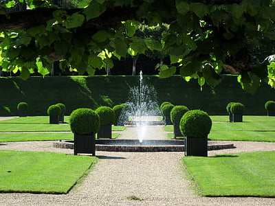 water fountain near bushes on vase during daytime thumbnail