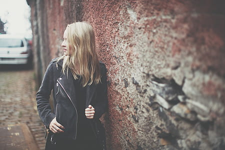 man leaning to maroon concrete wall while looking at the side thumbnail