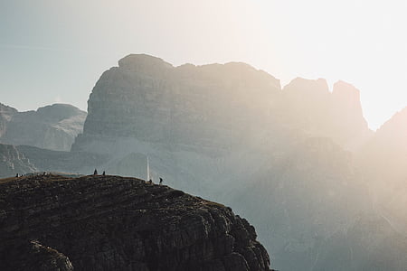 photo of several people on rocky hill during daytime thumbnail