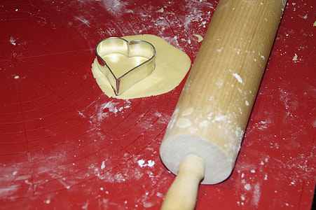 brown wooden rolling pin on red surface thumbnail