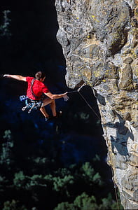 man jumping at cliff with rope at daytime thumbnail