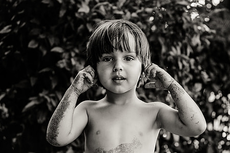 grayscale photo of a boy touching his ears thumbnail