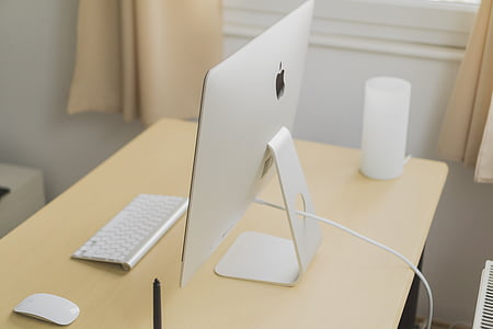 Magic Keyboard 2 beside Magic Mouse and silver iMac on wooden surface thumbnail