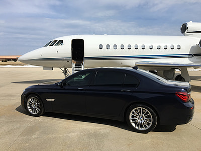 black car parking beside white airplane thumbnail