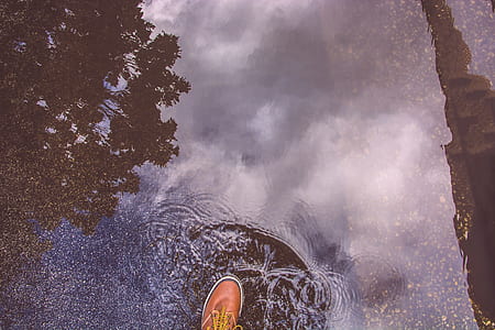 unpaired brown leather lace-up dress shoe stepping on water thumbnail