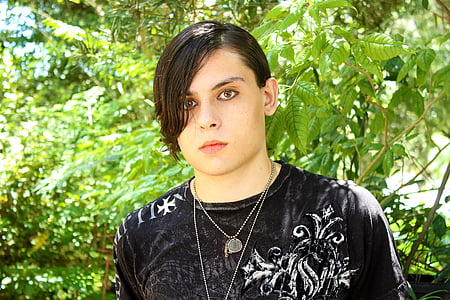 man in black crew-neck shirt in front of green leafed plants thumbnail