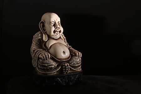 white Buddha figurine on black surface thumbnail
