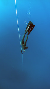 man in green wetsuit diving on body of water thumbnail