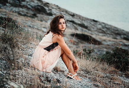 woman wearing dress sitting on cliff thumbnail