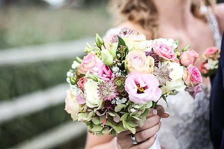 selective focus photography of woman holding bouquet of flowers thumbnail
