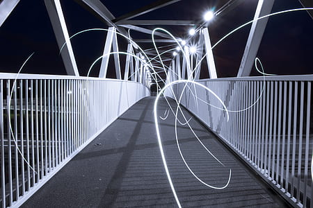 empty white and black well-lighted bridge during nighttime photo thumbnail