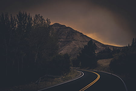 empty curved road near rock mountain thumbnail