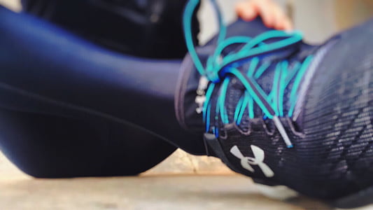 person wearing black leggings and black Under Armour running shoe thumbnail