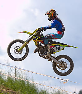 person riding motocross dirt bike doing stunt at daytime thumbnail