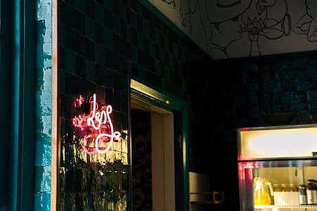 Less Neon Sign Mounted on Glass Board Near Open Window and Glass Display Rack thumbnail