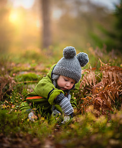 toddler's wearing knit cap sitting on green grass thumbnail