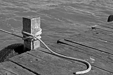 grayscale photo of rope tied on brown post thumbnail