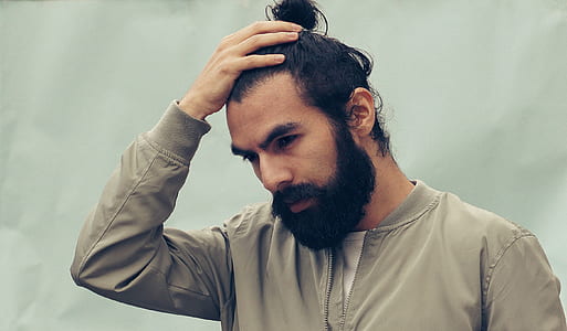 man looking downward while touching his hair thumbnail
