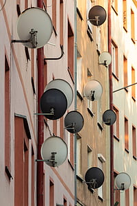 photo of gray parabolic dishes outside of residential building windows thumbnail