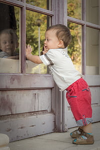 child facing smoke-glass window thumbnail
