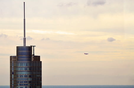 airliner in flight near high-rise building thumbnail