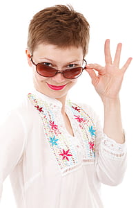 woman holding her sunglasses inside white painted wall room thumbnail