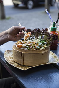 person eating food using chopsticks at daytime thumbnail