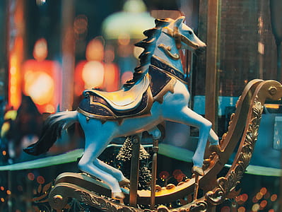 selective focus photography of white and brown rocking horse ride thumbnail