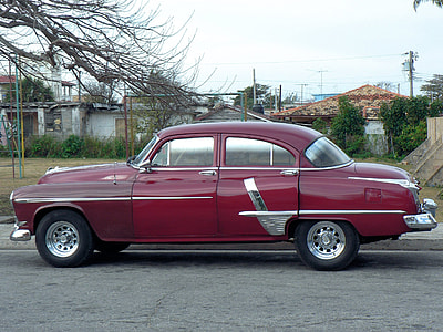 classic red sedan parked near tree thumbnail