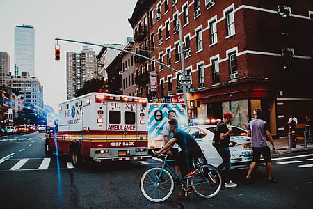 man riding bike near ambulance thumbnail