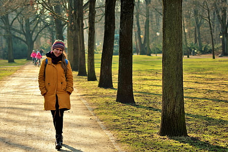 woman holding her jacket beside tree thumbnail