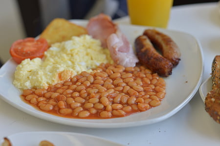 beans beside omelette and sausage on plate thumbnail