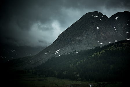 fault block mountains surrounded by pine trees under gray clouds thumbnail