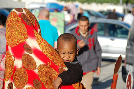 person carrying baby while walking along the street thumbnail