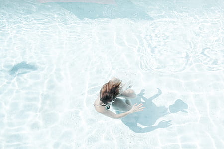 woman swimming in body of water thumbnail