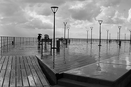 grayscale photography of couple holding umbrella thumbnail