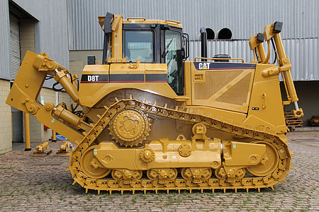 brown and black CAT heavy equipment outside the building thumbnail