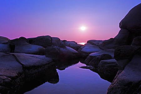 body of water surrounded rocks on sunset thumbnail