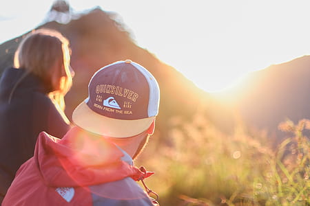 man wearing white and blue flat brimmed cap and red The North Face windbreaker thumbnail
