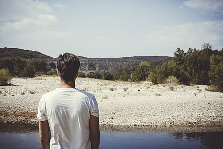 man in white crew-neck shirt looking at mountain thumbnail