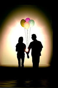 silhouette of couple holding hands with balloons thumbnail