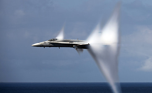 gray fighter plane flying over ocean during daytime thumbnail