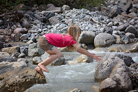 girl at rock jumping and reaching another stone thumbnail