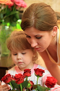 woman and girl looking at red rose flower bouquet thumbnail
