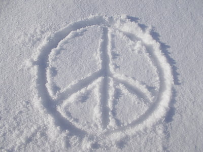 peace symbol on snow during daytime thumbnail