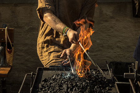 person in brown elbow-sleeved top igniting charcoal photo thumbnail