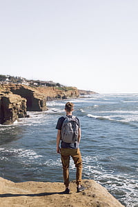 man standing on brown cliff thumbnail